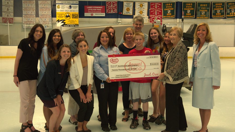 Membes from Jewel, Kraft Heinz , the McGee Family, and the Board on the Northbrook Sports Center ice receiving a check